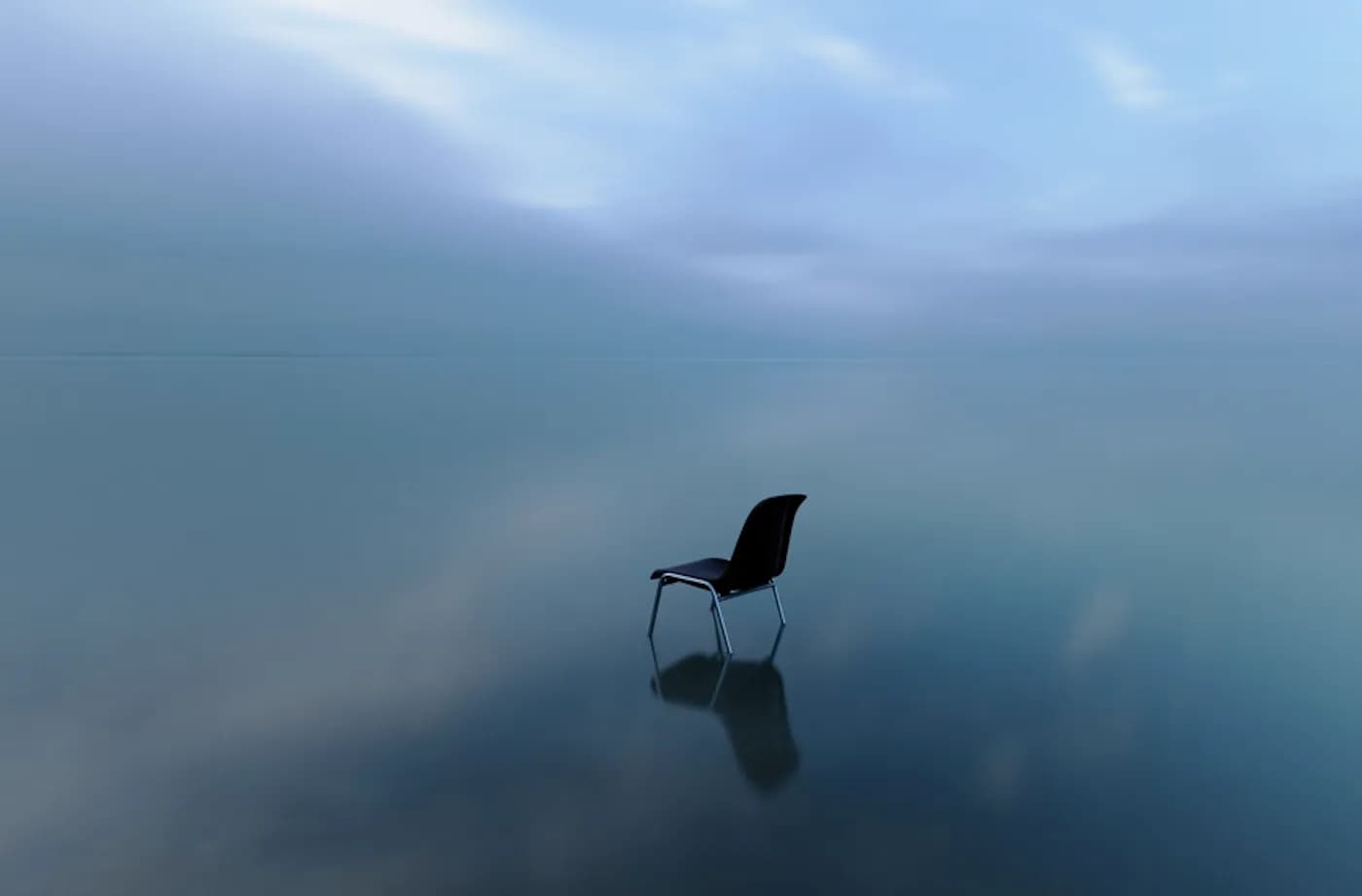 A single chair in calm blue fog